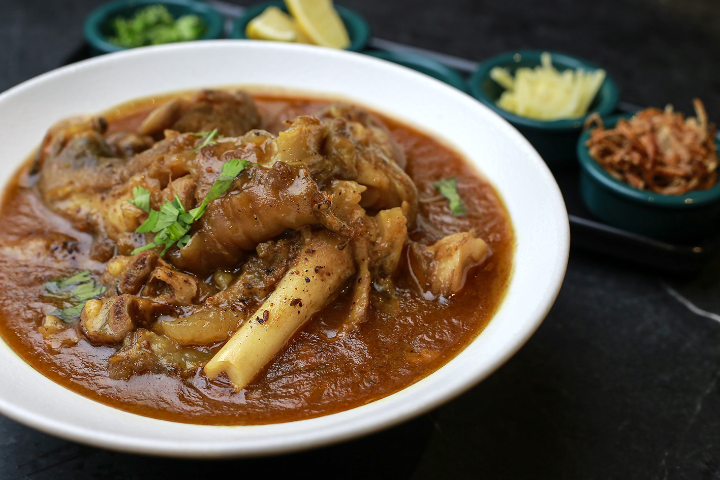 Bowl of paaye with garnishes